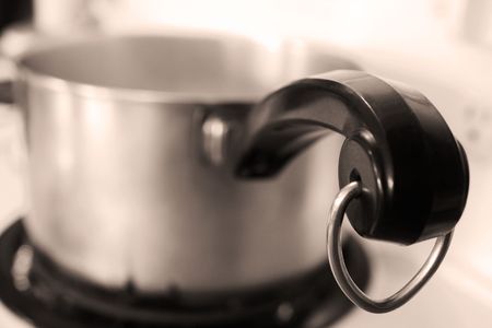 Old pot sitting on stove - tip of handle in focusの写真素材