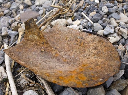 Rusty shovel without a handle lying on a beachの写真素材