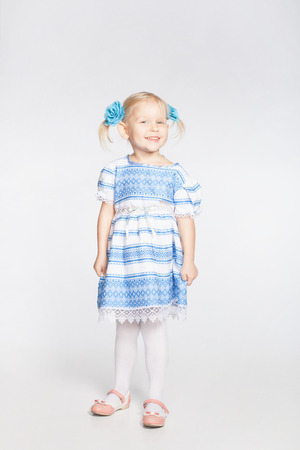 Cute smiling little blonde girl on a white backgroundの写真素材