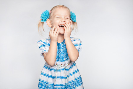 Laughing cute little girl on a white backgroundの写真素材