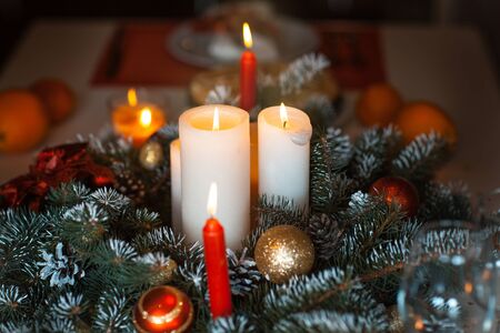 Candles in Christmas decorations of fir branches and toysの写真素材