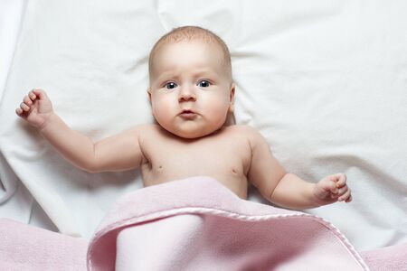 Little baby girl lying. She's waving handsの写真素材