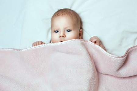 Little baby girl lying. She is covered with a veilの写真素材