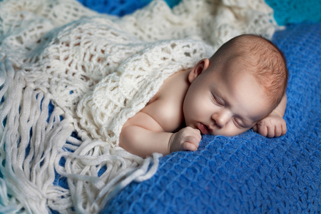 Beautiful baby girl sleeping. It is covered with a scarf knittedの写真素材