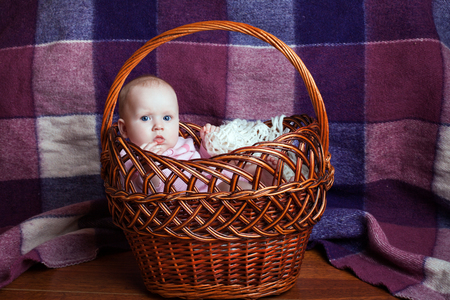 Little beautiful girl sitting in a basketの写真素材