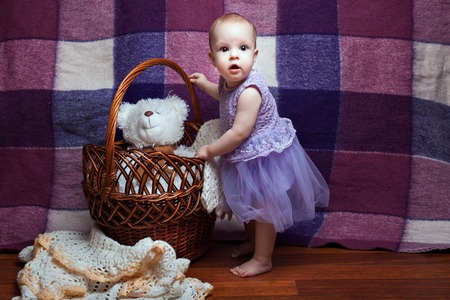 Little girl stands near the basket and looking surprisedの写真素材