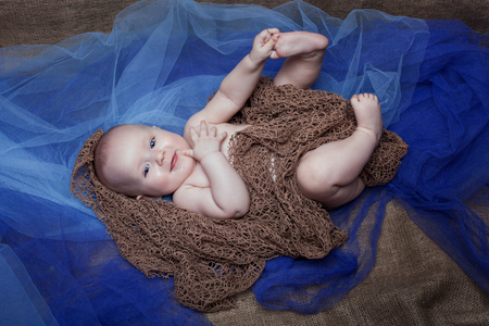 Beautiful baby girl on a blue background. Baby laughingの写真素材