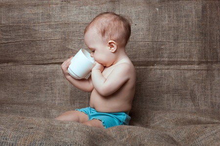Little baby girl looks into the cupの写真素材
