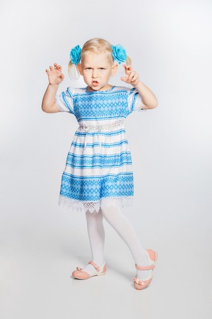 Portrait of beautiful blonde little girl. Girl grimacesの写真素材