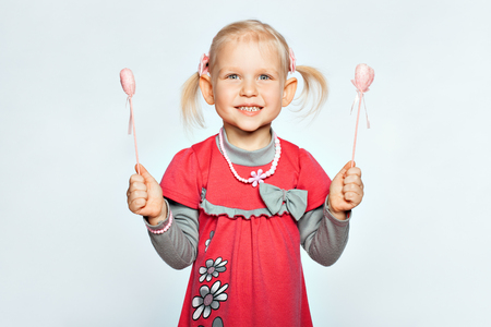 Baby blond girl holds the toy heartの写真素材