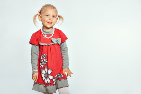 Baby blonde girl on a white background. Girl grimacesの写真素材