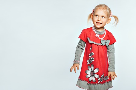 Beautiful blond baby girl on white background looks towardの写真素材