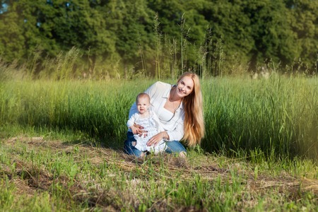 Young mother with her little daughter in a fieldの写真素材