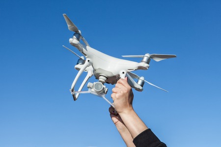 Men's hands hold the drone, pick it upの写真素材