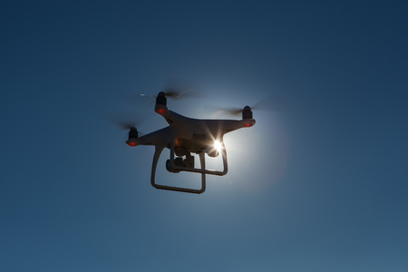 Quadrocopter against backlight. Copter against backlight. It is flying high in the skyの写真素材