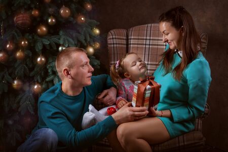 Young family in the living room by the Christmas treeの写真素材