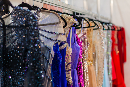 A lot of shiny evening gowns hang in the storeの写真素材