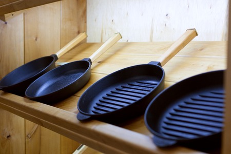 Set of new pans on a wooden shelf.の写真素材