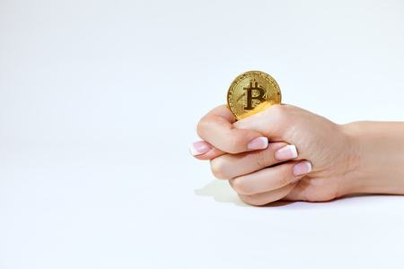 Female hand holds bitcoin and shows fig.の写真素材