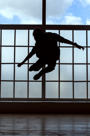 Silhouette of a young man. He makes the jumpの写真素材