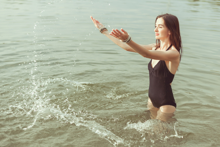 Beautiful woman in a bathing suit splashing in water.の写真素材