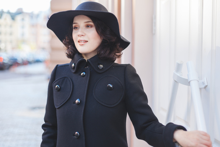 Cheerful full young woman in coat and hat.の写真素材