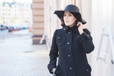 City life. Full young woman in coat and hat.の写真素材