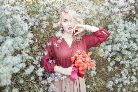 Portrait of a beautiful blonde woman in the park.の写真素材