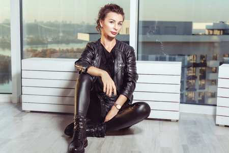 Beautiful young woman in black leather suit.の写真素材