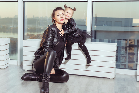 Portrait of a young mother and her daughter near a large window.の写真素材