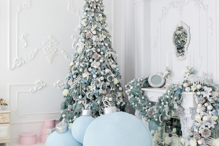 Beautiful Christmas tree stands near the fireplace in the corner of the room.の写真素材