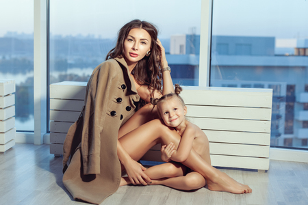 Portrait of a beautiful young family at the window. Mom and daughter.の写真素材