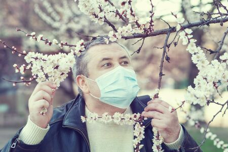 Man in a mask with frightened eyes standing on the street.の写真素材