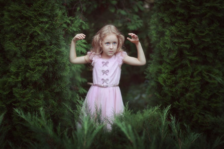 Portrait of a cute girl in a smart dress in a fairy forest.の写真素材