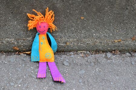 Handmade Colorful Shabby Felt doll with red hair against concrete backgroundの写真素材