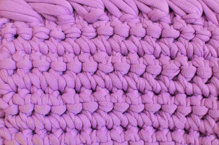 Lilac crochet texture made of knitted cotton yarn. Lilac handmade background - crafts and hobby