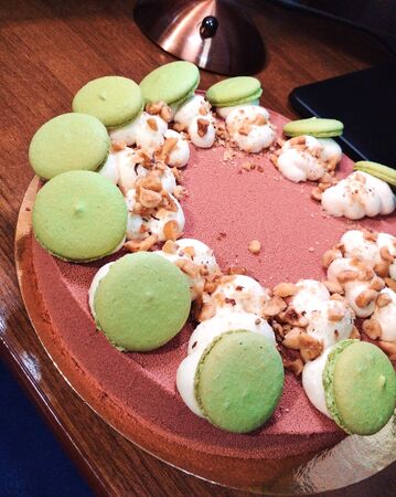 Sweet pink Birthday cake green macaroon white meringue cream nut tasty dessert food photo.