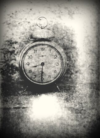 Old photo of the alarm clock - grained, scratched, overexposure and underexposure, unfocused, overall poor and non commercialの写真素材