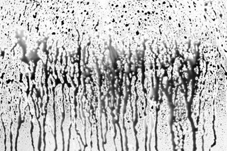 Abstract Black Dropping Splatters on White Surfaceの写真素材
