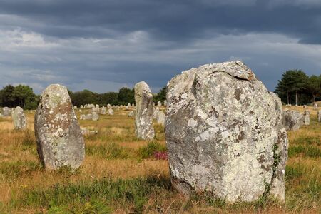 Alignements du Menec  - rows of Menhirs - standing stones in light of sunset - the largest megalithic site in the world, Carnac, Brittany, Franceの写真素材