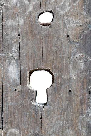 Detail of the keyhole in old damaged doorの写真素材