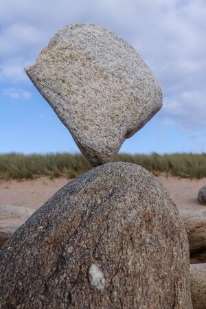 Stone balancing on stone - stone laid on other stone on seacoastの写真素材