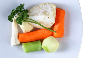 Vegetables for soup - carrots, celery, parsley, leek, cauliflower, onions - on plateの写真素材