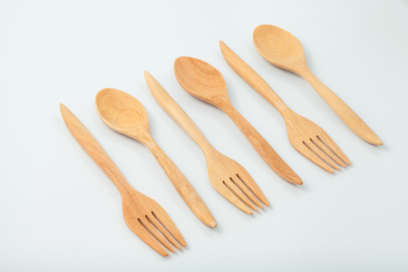 brown wooden spoons and fork on white backgroundの写真素材