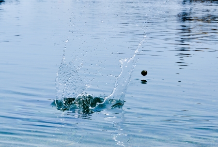 stone bouncing fast on the water surfaceの写真素材