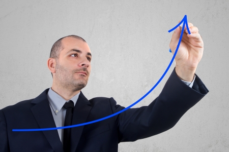 businessman in blue dress hand draws an arrowの写真素材