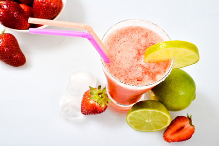 Frozen strawberry margarita isolated on a white background garnished with a salt rim and a lime wheel.の写真素材