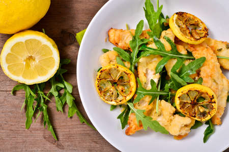 Italian Cuisine: Chicken with arugula and lemon on wooden tableの写真素材