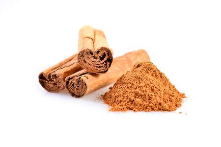 macro photograph of cinnamon sticks dry beside a teaspoon of ground cinnamonの写真素材