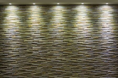 Stone wall with spotlights that illuminate from above